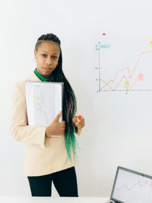 Confident analyst presenting financial data and growth charts in a modern office setting.
